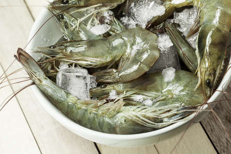 A bowl of fresh raw shrimps cooled with the iceの写真素材