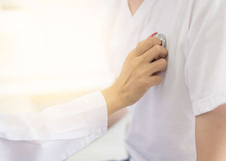 Medical concept.Doctor is checking on patient's chest uses stethoscope to listen patient heart rateの写真素材