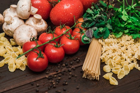 Ingredients, pasta, tomatoes, mushrooms, herbs vegetables and spices Italy wood eat deliciousの写真素材