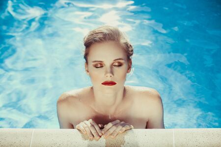 Young girl model relax in swimming pool with clear blue water. Full relax. Vintage. Spaの写真素材