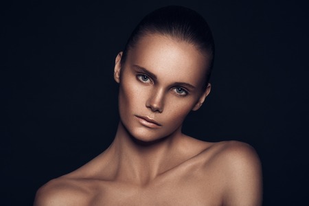 nude make up, strong woman, green eyes, studio shoot, dark background, highlight skin, model posing and looking at the cameraの写真素材