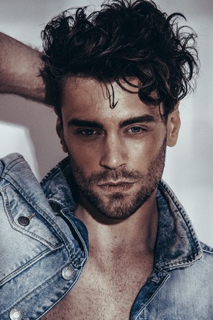 Confident and handsome. Jeans jacket. Looking at camera. Fashion shooting. Hairstyleの写真素材