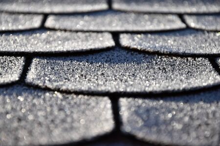 Roof with asphalt shingles is frostbitten. Frost.の写真素材