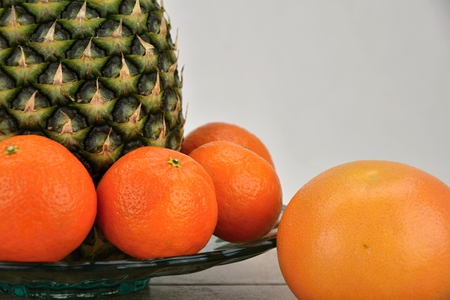 Tropical fruit on a platter, pineapple, mandarin and grapefruit. Detail. Fruit.の写真素材
