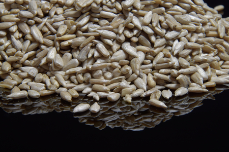 Sunflower peeled seeds on a black background. Seed.