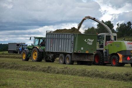 Svitavy, Czech Republic - 20.4.2019: Forage harvest. The John Deere tractor and Claas are harvesting clover for haylage. Agricultural field workのeditorial素材