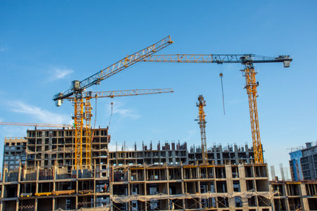 Crane and building under construction against blue sky, Moscow, Russia
