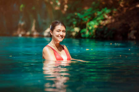 young Latina woman standing in blue green waters of Rio Blanco in Costa Rica. High quality photoの写真素材