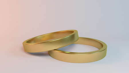 Couple of gold wedding rings on white background inside a 3d stageの写真素材
