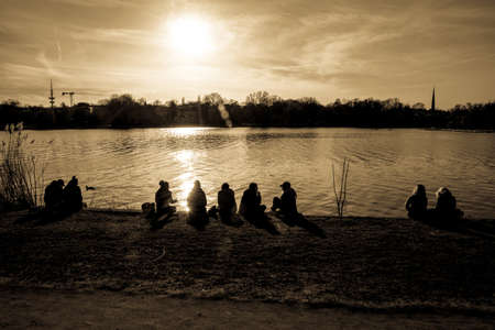 people sitting near the lakeの写真素材