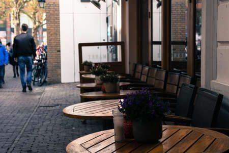 outside restaurant tables in a crowded streetの写真素材