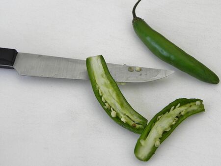 Cut serrano pepper with another in the backgroundの写真素材