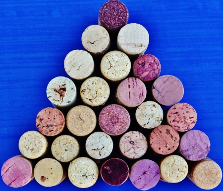 Used wine corks arranged in a triangular pattern against a blue background の写真素材