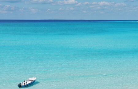 A fishing boat floating in the crystal blue calm ocean waters of the Caribbean Sea の写真素材
