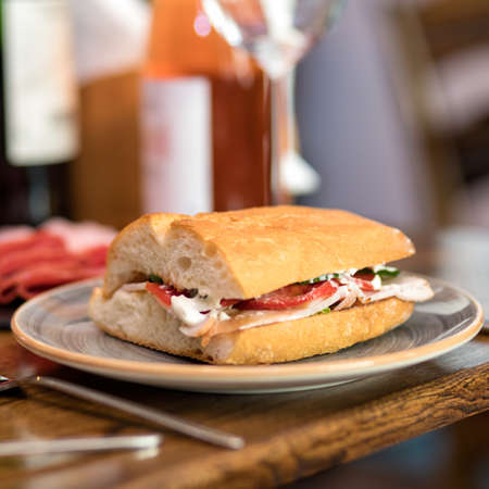 Tasty sandwich with red wine on the tableの写真素材