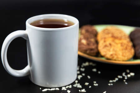 Tasty chocolate cookies with a tea cup on the black backgroundの写真素材