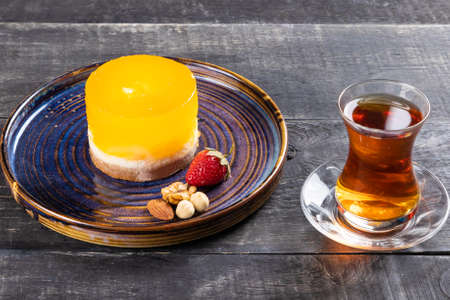 Beautiful yellow dessert with glass of teaの写真素材