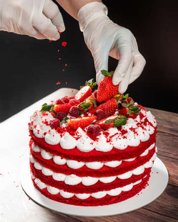 Tasty red strawberry chocolate cake, pouring ingredientの写真素材