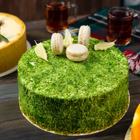 Different beautiful macaron cake on the wooden table with teaの写真素材