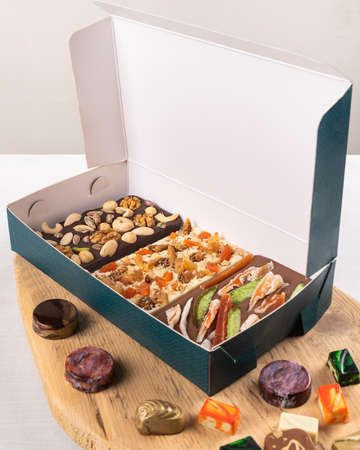 Luxury chocolate pieces, rose, pomegranate, nuts in the boxの写真素材