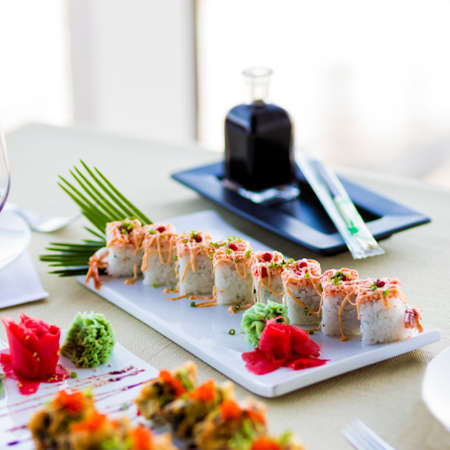 Sushi Set nigiri and sushi rolls with sauce served on white plate on the restaurant table