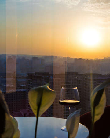 Red wine glass with city view, sunset viewの写真素材
