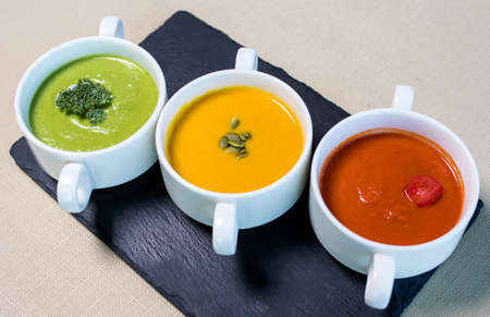 Colorful tasty soups on the black plateの写真素材