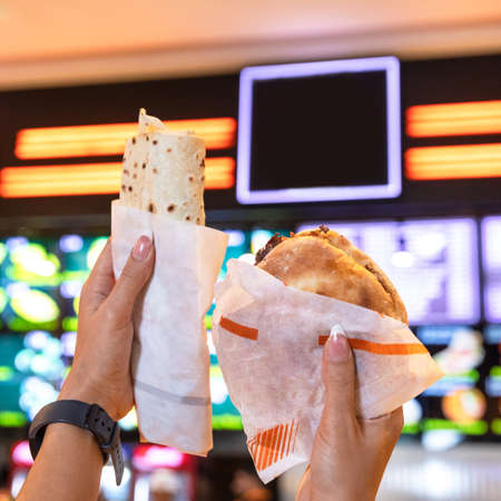 Woman holding burger, doner