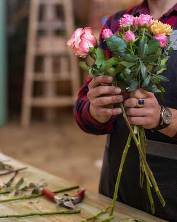 Florist man making flower bouquet at the storeの写真素材