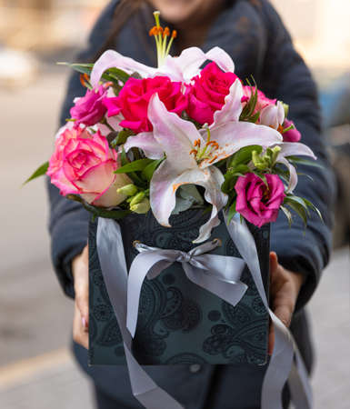 Woman holding beautiful flower bouquet in the boxの写真素材