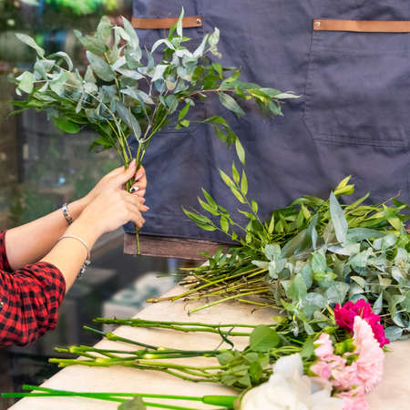 Florist woman making flower bouquet at the storeの写真素材