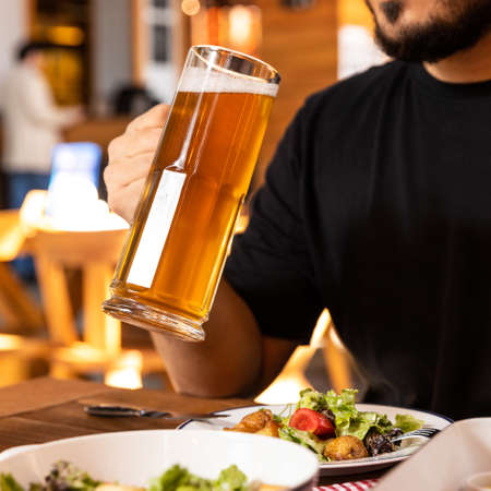 Man drinking beer with saladの写真素材