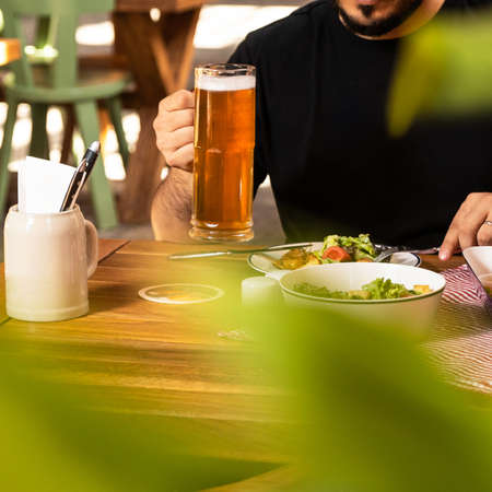 Man drinking beer with saladの写真素材