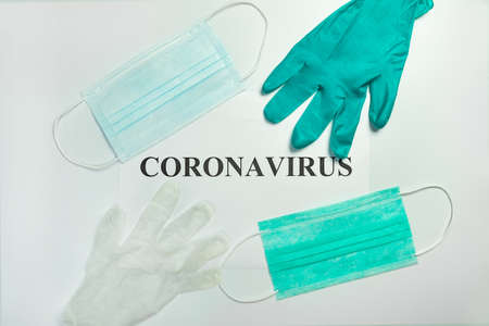 Medical protective masks with gloves on the table with Coronavirus wordの写真素材