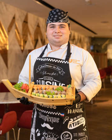 Chef holding sushi set in ship shaped plateのeditorial素材