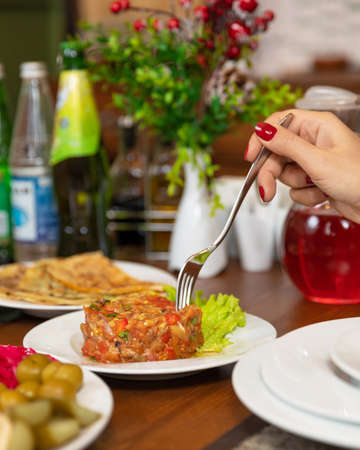 Woman eating eggplant saladの写真素材