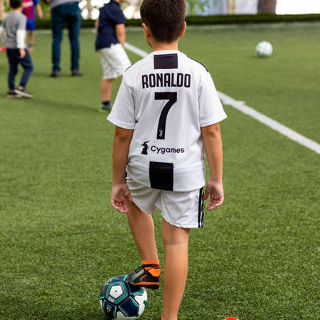Young boy standing with soccer ball at the stadium