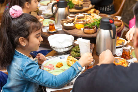 Family at breakfast, baby girl drinking tea