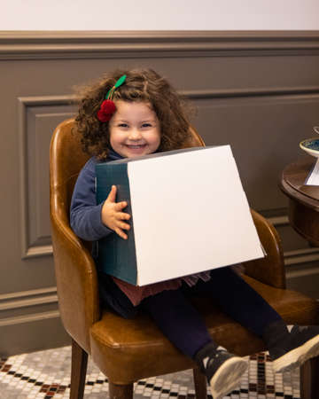 Little beautiful girl holding a big white box and smilingのeditorial素材