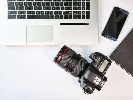 Photographer desk, professional camera with a laptop on the table top view