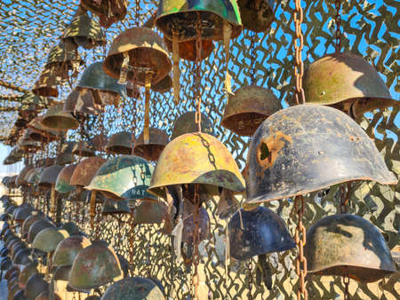 The old rusty soldier's helmets on the wall, one with bullet hole - Baku, Azerbaijan, 04-16-2021のeditorial素材