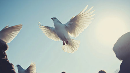 White dove flying in a blue sky with spread wings, surrounded by other doves and peopleの素材