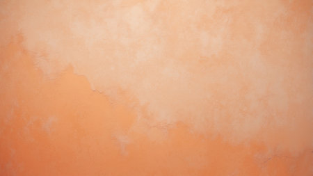 A warm orange wall displays a textured surface with soft variations in color. Its serene appearance serves as an ideal backdrop for interior spaces or artistic displays.の素材