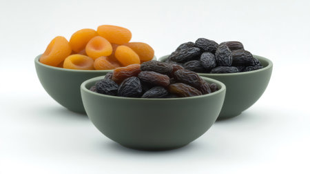 Three green bowls are filled with various dried fruits, creating a vibrant display of healthy snacksの素材