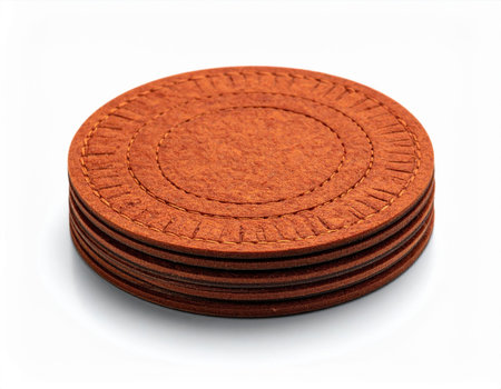 A set of circular, stitched felt coasters in a rich brown hue are neatly stacked, offering a rustic and practical addition to any table settingの素材