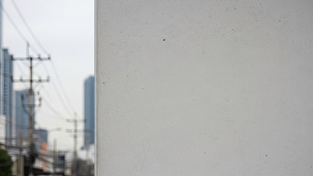 A juxtaposition of industrial infrastructure and modern architecture with a focus on a rough concrete surfaceの素材