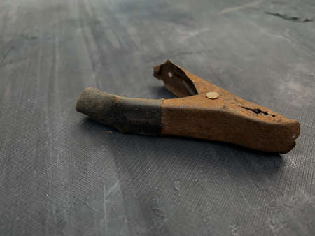 old rusty battery clip unused on gray backgroundの写真素材