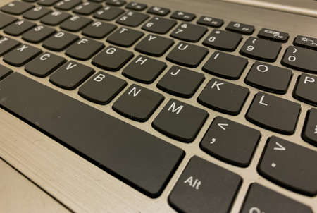 laptop keyboard with dark color and white font