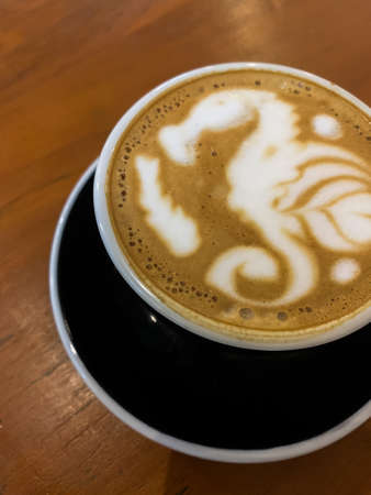 a cup of cappuccino with a seahorse motifの写真素材