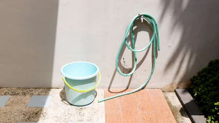 a water hose that is rolled up on a water faucetの写真素材